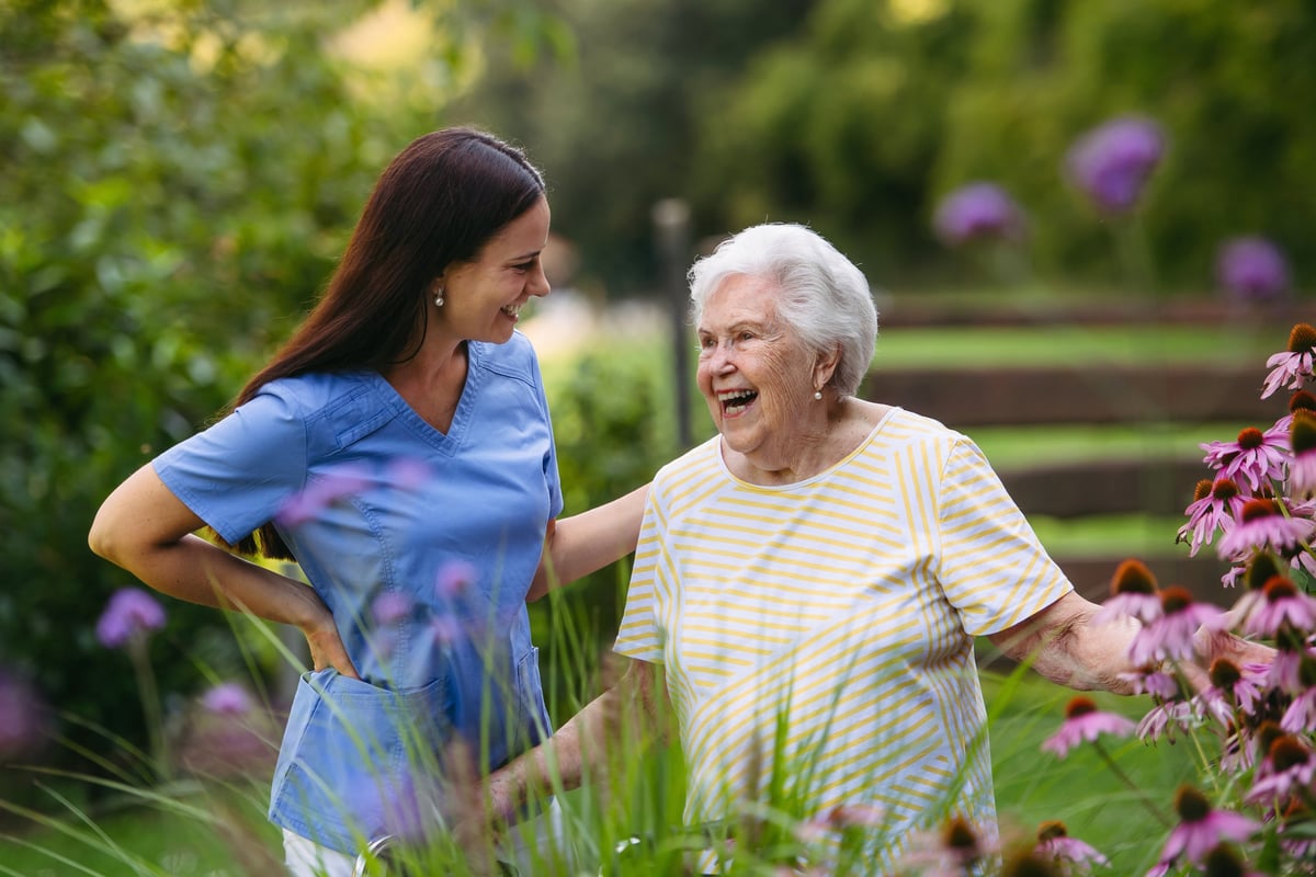 A home care nurse spending time with an elderly lady in the garden